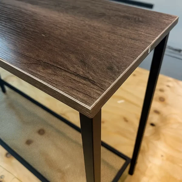 Wooden corner table with dark metal legs.