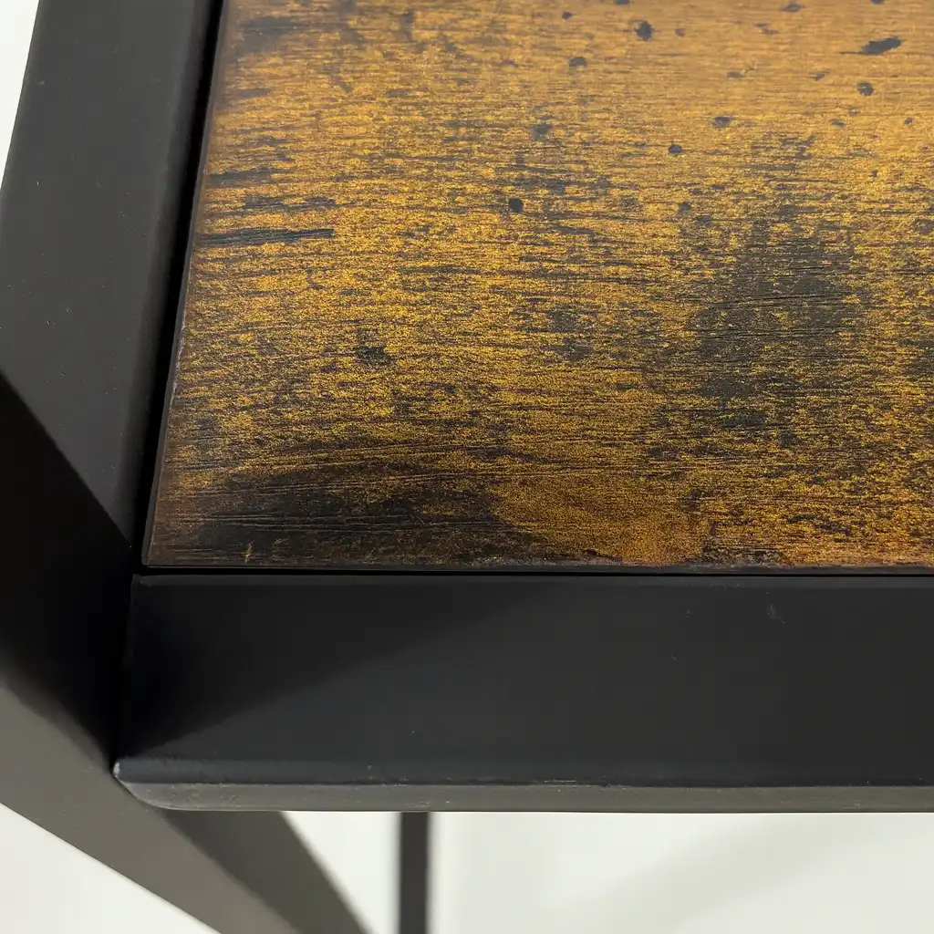 Close-up of wood and metal table edge.